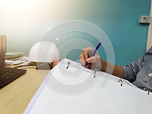 Engineer inspecting and checking datasheet.