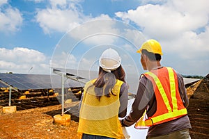 Engineer inspector male and female working in solar panel electric farm.photovoltaic cell park green energy concept