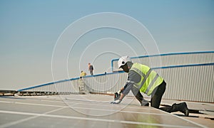 Engineer installing solar panels working on the roof