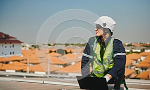 Engineer installing solar panels working on the roof