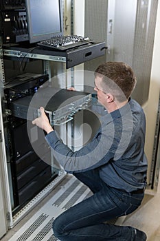 IT Engineer installs equipment to rack in datacenter