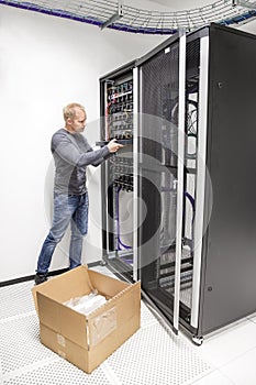 IT engineer installs network switch in datacenter