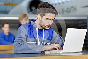 engineer looking at laptop for airplane maintenance