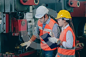 Engineer male training and check machine with woman worker team in metal industry factory