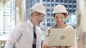 engineer man and business woman working with laptop computer talking and checking plans together in construction site building