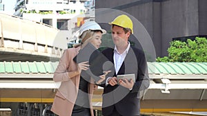 Engineer man and business  woman working with tablet and note book talking and checking plans together in construction site