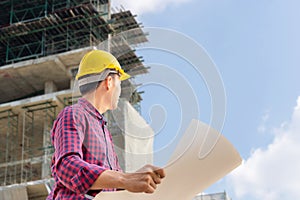 Engineer man with clipping path checking and planning project at construction site, Man holding blueprint and looking into the sky