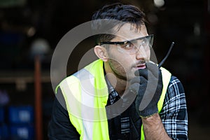 Engineer man or factory worker using walkie-talkie and feeling happy