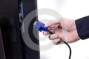 IT engineer Man hand inserts cable into monitor. Man hand connecting the DVI cable for monitor to computer PC. VGA DVI DisplayPort