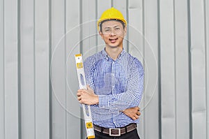 Engineer Man holding level measuring instrument and standing at container