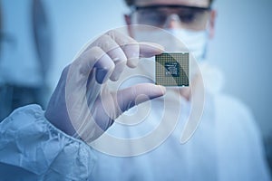 Engineer man  in sterile suit is holding Microchip with symbols in modern design factory  , futuristic and artificial intelligence