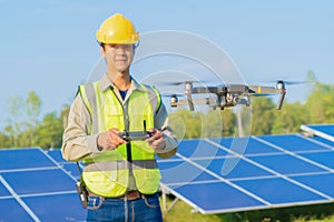 Engineer man or worker, people, using a drone to survey. Solar panels or solar cell on the roof in farm. Power plant with green