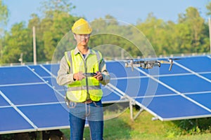 Engineer man or worker, people, using a drone to survey. Solar panels or solar cell on the roof in farm. Power plant with green