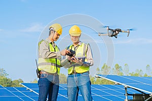 Engineer man or worker, people, using a drone to survey. Solar panels or solar cell on the roof in farm. Power plant with green