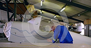 Engineer marking a line on airplane parts 4k