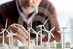 An engineer with a models of a wind turbine. Green energy and environmental concept.