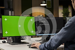 Engineer in office automating tasks using scripts on green screen PC