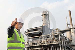 Engineer oil refinery with thumbs up gesture