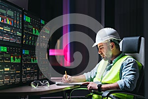 Engineer operator and computer screens with modern following production system Industry 4.0 Head engineer of factory control