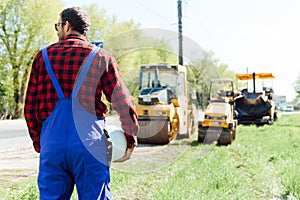 Engineer orders for workers to work safely at construction site, workers put asphalt on the road