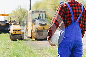 Engineer orders for workers to work safely at construction site, workers put asphalt on the road