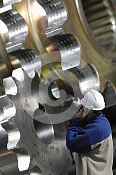 Engineer pointing at gears machinery