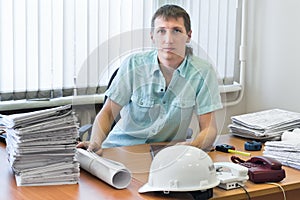 Engineer with project drawings in office