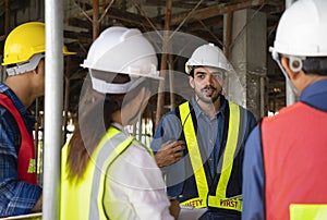 engineer project manager holding walkie talkie talking to work team on the building under construction,engineer teams wearing full