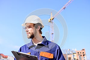 Engineer protective helmet stand in front of blue sky background. Builder engineer helmet works at construction site
