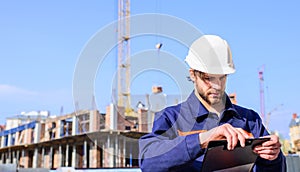 Engineer protective helmet stand in front of blue sky background. Contractor control according to plan. Builder engineer
