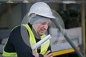 Engineer with protective workwear freezing outdoors