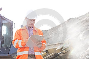 Engineer reading clipboard at construction site