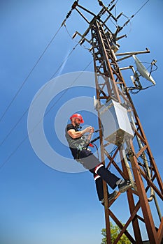 Engineer in red helmet working on power transmission line