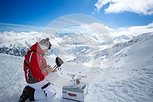 Engineer with remote controls quadrocopter drone a the mountains