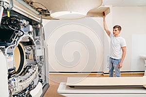 engineer removes cover of a computer tomograph.