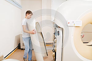 engineer removes cover of a computer tomograph.