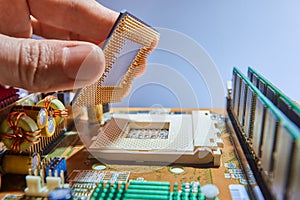 Engineer repairman holding chip CPU to insert into the socket of computer motherboard. Concept of technology hardware