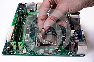 Engineer repairman holding hands in black gloves chip processor, CPU to insert into the socket of the computer motherboard. The