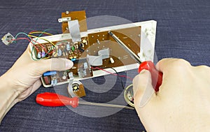 Engineer repairs chip board with a screwdriver