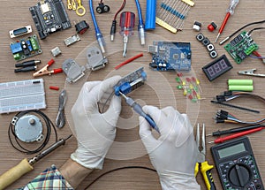 An engineer's hands are assembling a breadboard from an Arduino microcontroller