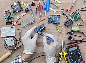 An engineer's hands are assembling a breadboard from an Arduino microcontroller,