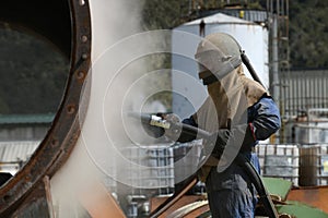 Engineer sandblasting a steel casing