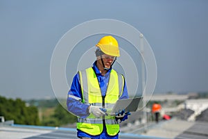 Engineer service check installation solar cell on the roof of factory.