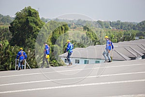 Engineer set installation and inspect standards of solar panels on roof of an industrial factory. Team technician inspection