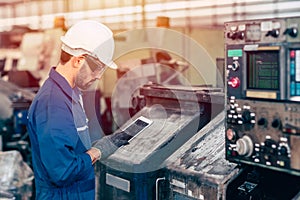 Engineer setup the CNC machine with G-Code programming upload from Computer Tablet for technology in heavy industry