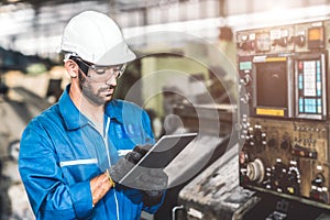 Engineer setup the CNC machine with G-Code programming upload from Computer Tablet for technology in heavy industry