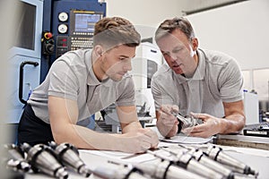 Engineer Showing Apprentice How To Measure CAD Drawings photo