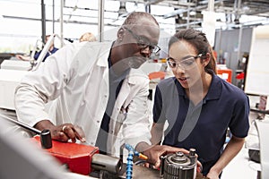 Engineer showing equipment to a female apprentice, close up