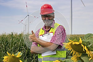 Engineer Shows Thumb Up At Energy Park with Wind Turbines