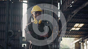 Engineer standing holding wrench tools and arms crossed at work in the industry